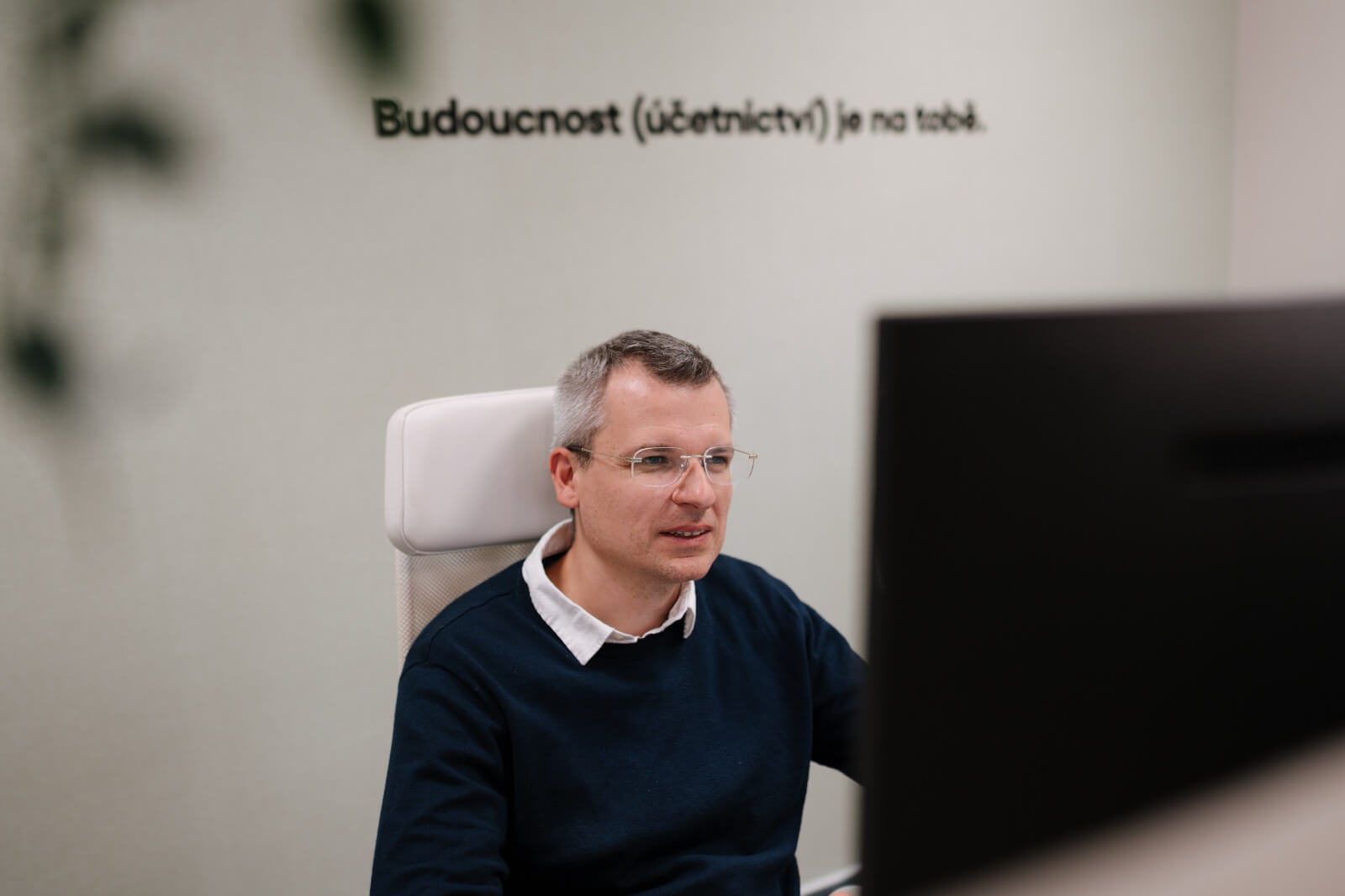 Kolega u monitoru, na stěně nápis Budoucnost (účetnictví) je na tobě